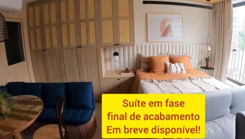a bedroom with a bed and a couch and a table at Pousada Ideal Guarujá - Estúdios Mobiliados, Ar-Condicionado e Cozinha in Guarujá