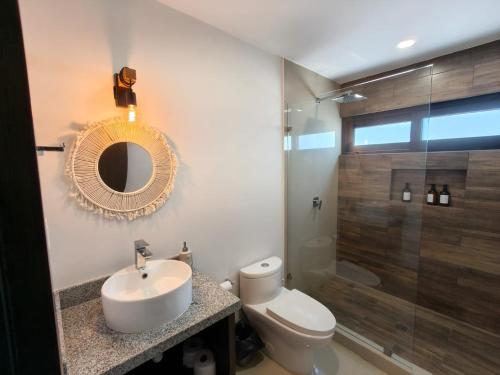 a bathroom with a sink and a toilet and a mirror at Departamento cerca del Malecón in Mazatlán