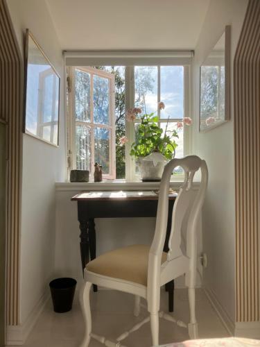 a chair sitting at a desk in front of a window at B&B Österlens RosenTrädgård in Glemmingebro