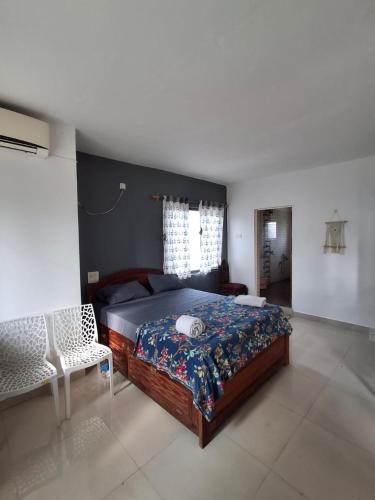 a bedroom with a bed and a chair in it at White House Beach Apartments in Mandrem