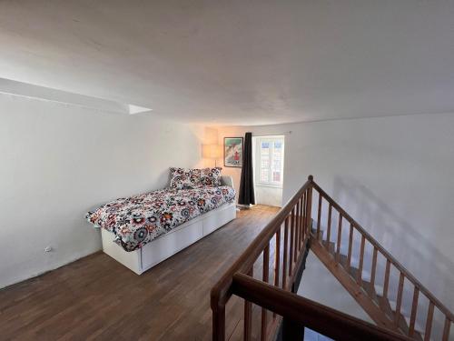 a bedroom with a bed in a room with a staircase at La Petite Ecluse, maison d'artistes in Tanlay