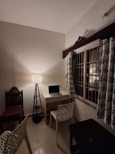 a living room with a desk and a laptop computer at White House Beach Apartments in Mandrem