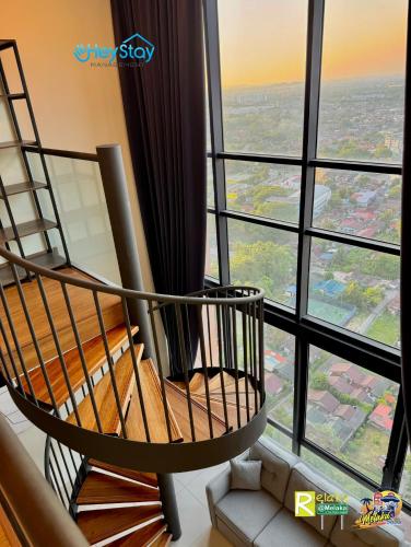 a room with a spiral chair in front of a window at The Apple Residence By Heystay Management in Melaka