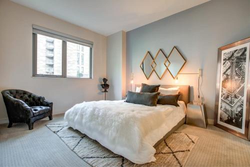 Un dormitorio con una cama grande y una silla. en Luxury 1bedroom 1bath Space Needle, en Seattle