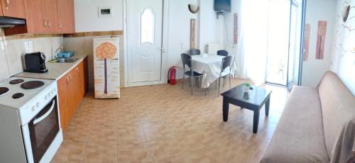 a kitchen and living room with a couch and a table at Laggada House in Agia Pelagia Kythira
