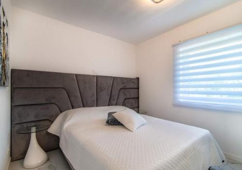 a bedroom with a bed with a large headboard and a window at Luxury Apartment Queens on two floors with a panoramic sea view in Dramalj