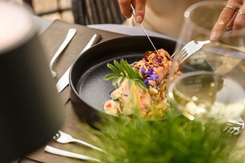 a person eating food in a bowl with a fork at Aktivhotel Gasteiner Einkehr in Dorfgastein