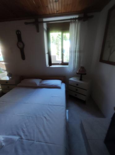 a bedroom with two beds and a window at Trikeri traditional cozy house in Trikeri