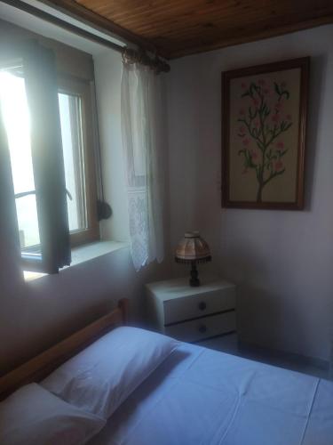 a bedroom with a bed and a window at Trikeri traditional cozy house in Trikeri