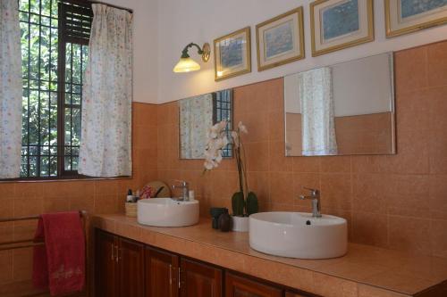 a bathroom with two sinks and two mirrors at HELFAROAN Spacious, Superb panoramic view! in Kandy