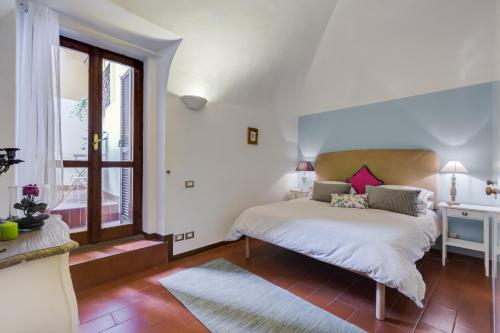 Purificazione 44 Guest House في روما: غرفة نوم بسرير ونافذة كبيرة