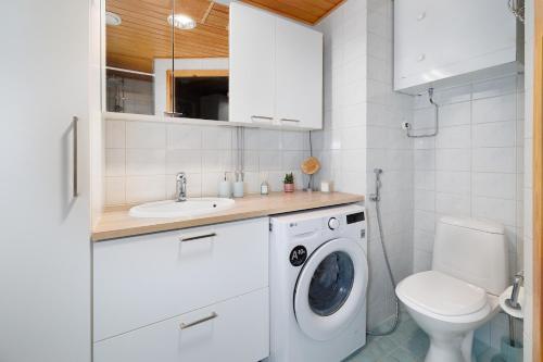 a bathroom with a washing machine and a toilet at Downtown Oulu 2BR, Sauna & Sea View Balcony in Oulu