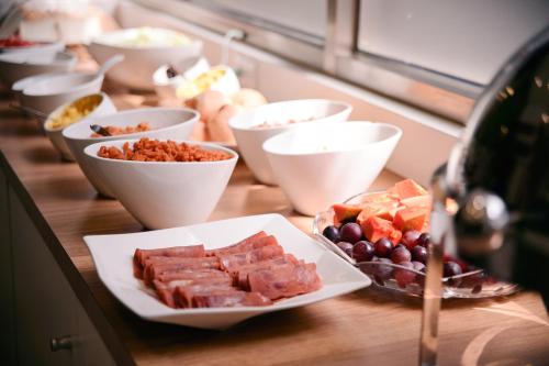 a table with plates of food and bowls of fruit at KIWI-Taichung Station Branch 1 in Taichung
