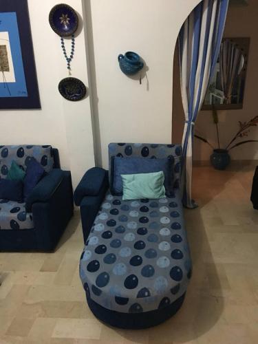 a living room with a blue couch and a chair at Appartement 3 chambres bords de mer Hammamet in Nabeul