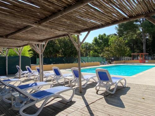 un groupe de chaises assises à côté d'une piscine dans l'établissement Camping de l'Arnel, à Villeneuve-lès-Maguelone