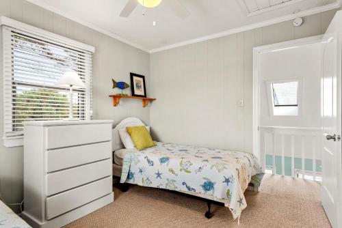 a bedroom with a bed and a dresser and a window at A Shore Thing in Duck in Duck