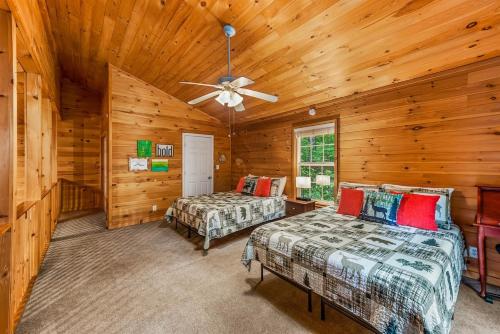 a bedroom with two beds and a ceiling fan at Peaceful Hideaway Treehouse near Little River Canyon in Fort Payne