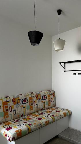 a couch sitting in a room with two lights at B&B Stretto Vibes in Reggio Calabria