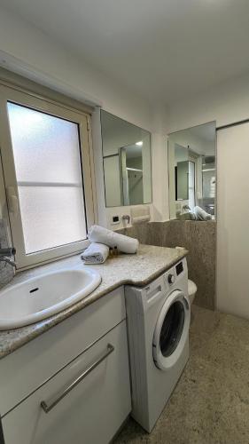 a bathroom with a sink and a washing machine at B&B Stretto Vibes in Reggio Calabria