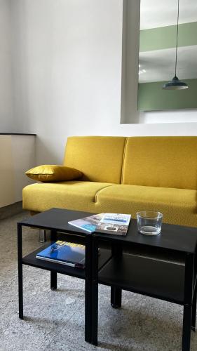 a living room with a yellow couch and a coffee table at B&B Stretto Vibes in Reggio Calabria