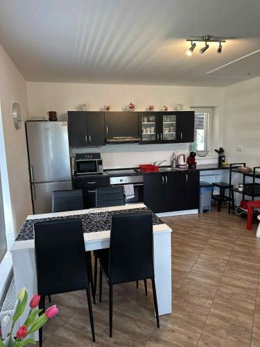 a kitchen with black cabinets and a table and chairs at Apartmány Na Rozcestí in Lomnice nad Popelkou