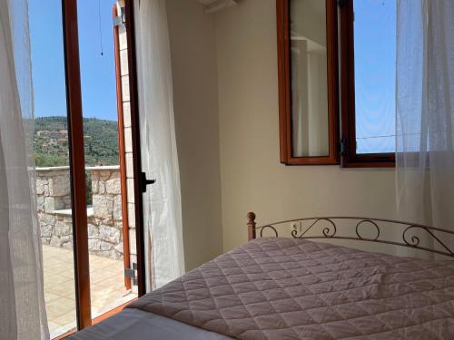 a bedroom with a bed and a view of a balcony at Poliana Holiday Home in Kotrónion