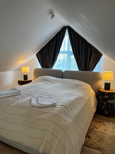 a bedroom with a large bed with a large window at Girios Horizontas - Mara in Trakai
