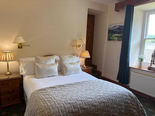 a bedroom with a bed and two lamps and a window at Craig-Y-Nos Castle in Abercraf