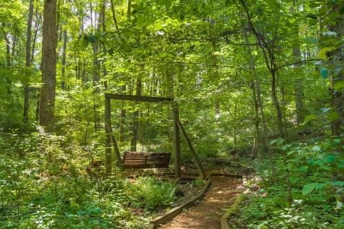 a bench in the middle of the woods at Peaceful Hideaway Treehouse near Little River Canyon in Fort Payne