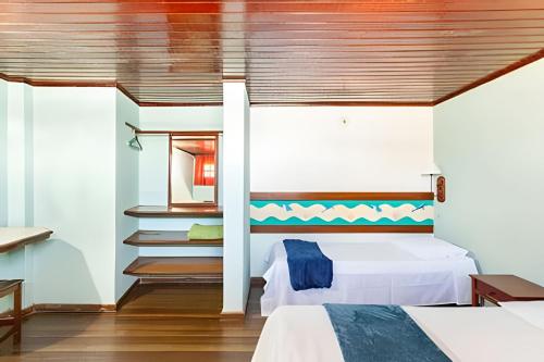 a bedroom with two beds and a wooden ceiling at Flat 208-A Vista Mar com Piscina in Cabo Frio