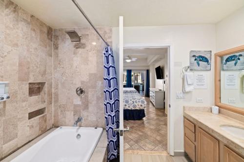 a bathroom with a bath tub and a bedroom at Las Palmas 2BR 2BA Suite Ground Floor- D101 in Campo del Medio