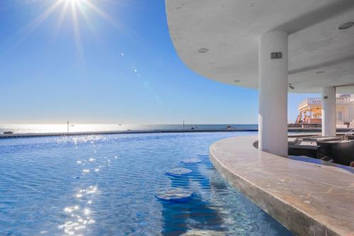 a swimming pool with the ocean in the background at Las Palmas 2BR 2BA Suite Ground Floor- D101 in Campo del Medio