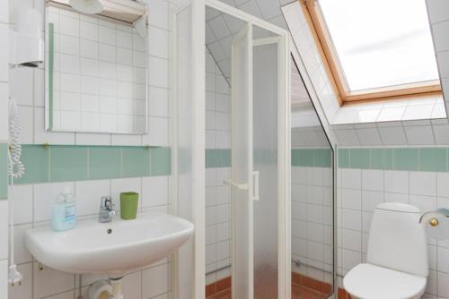a bathroom with a sink and a toilet and a window at Branteviks Bed o Breakfast in Brantevik