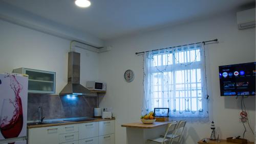 a kitchen with a window and a table and a refrigerator at Vivienda Crispin in Arguineguín