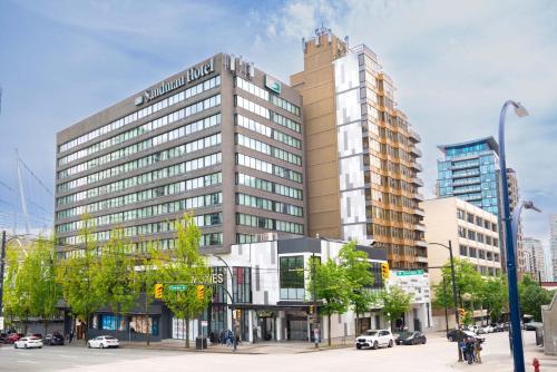 a large building on a city street with cars at Sandman Hotel Vancouver Downtown in Vancouver