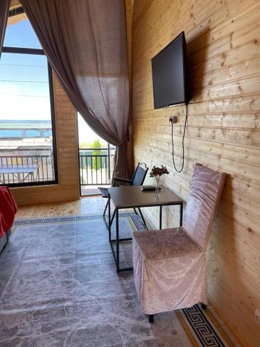 a room with a table and a television on a wall at Royal Ak-Terek Issyk-kul in Ak-Terek