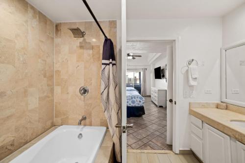 a bathroom with a bath tub and a bedroom at Las Palmas 2BD 2BA Suite Ground Floor- B101 in Campo del Medio