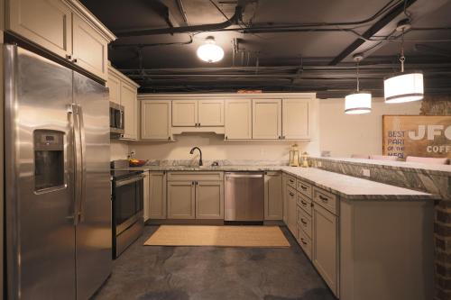a kitchen with white cabinets and a stainless steel refrigerator at Friedmans Loft in Knoxville