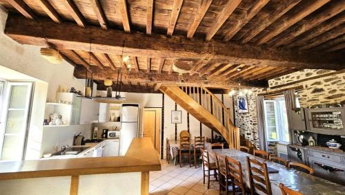 a kitchen and dining room with a wooden ceiling at Gîte de France "les volets bleus" 3 épis - Gîte de France 12 personnes MAE-9484 in Espartignac