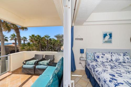 a bedroom with a bed and a balcony with palm trees at Las Palmas 2BR 2BA Suite 2nd FL Ocean View- G205 in Campo del Medio