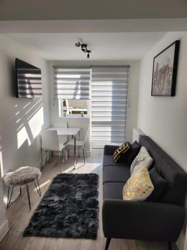 a living room with a couch and a table at Ensuite deluxe home in Basildon