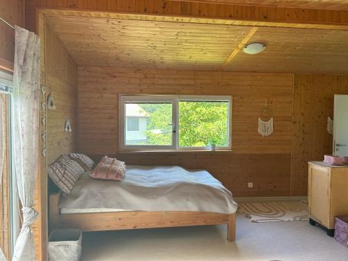 a bed in a wooden room with a window at Chata na soutoku in Kestřany