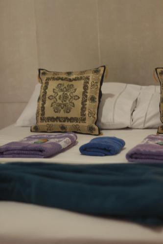 a bed with a pillow and two pillows on it at Pousada Bosque das Borboletas in Sabará