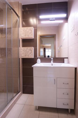 a bathroom with a white sink and a shower at Apartmenthaus Esther in Ramingstein