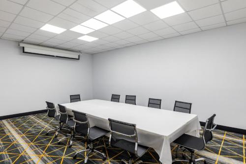 a conference room with a white table and chairs at Holiday Inn Port Arthur - Park Central by IHG in Port Arthur