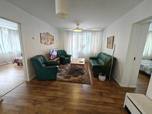 a living room with two green couches and a table at Holiday Ap in Visaginas