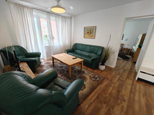a living room with two green couches and a table at Holiday Ap in Visaginas