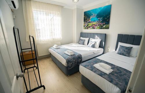 a bedroom with two beds and a painting on the wall at Downtown Bayrak Residences Trabzon in Trabzon