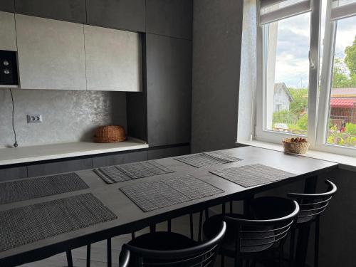 una cucina con un tavolo con sedie e una finestra di ViLLA KUMANETS a Skhidnytsia