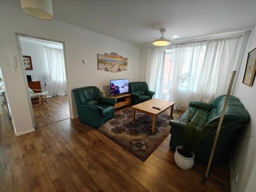 a living room with two green chairs and a table at Holiday Ap in Visaginas